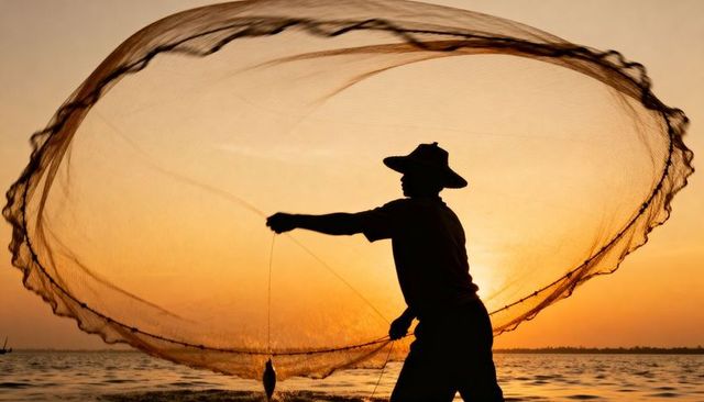Fisherman casting circular net at sunset silhouette over coastal water golden hour