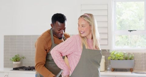 Smiling Couple Bonding While Cooking Together at Home Kitchen