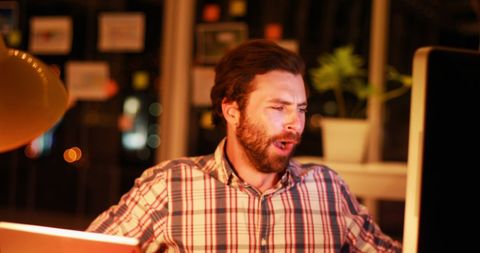 Yawning businessman working late in office at night