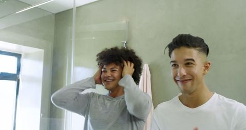 Friends in Bathroom Talking and Adjusting Hair Near Mirror