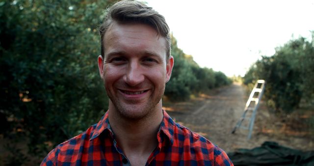 Young Man Smiling in Orchard During Harvest Season - Download Free Stock Images Pikwizard.com