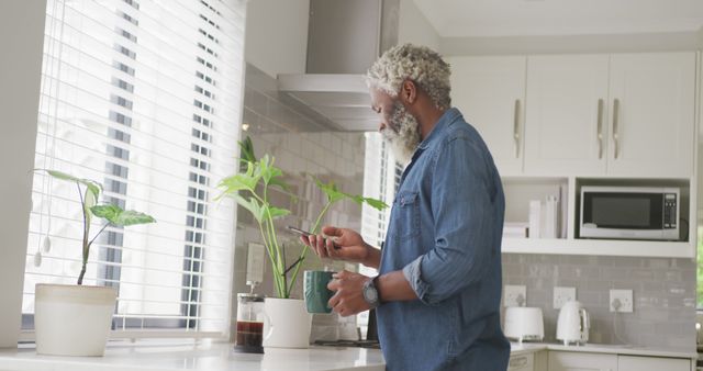 Senior Man Enjoying Morning in Modern Kitchen with Plants - Download Free Stock Images Pikwizard.com