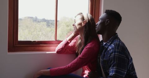 Happy Couple Embracing by Window on Sunny Day