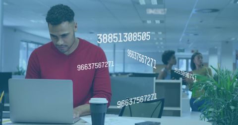 Focused man typing on laptop with digital data in office environment
