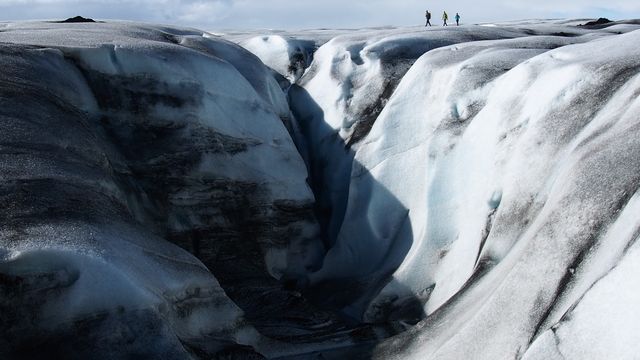 Dramatic Glacier Crevasse with Three Hikers in the Distance - Download Free Stock Photos Pikwizard.com