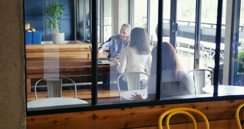 Senior Colleague Collaborating with Young Professionals in Stylish Office