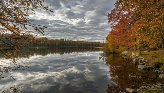 Tranquil Autumn Lake Reflecting Cloud-Laden Sky