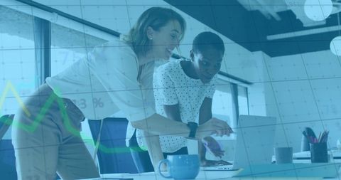 Diverse women collaborating with business analytics display