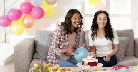 Women Joyfully Celebrating Birthday Party with Balloons and Cake