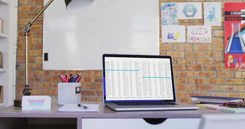 Laptop with Data Displayed in Office with Informational Posters - Download Free Stock Images Pikwizard.com
