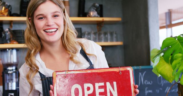 Smiling female barista holding open sign at coffee shop - Download Free Stock Images Pikwizard.com