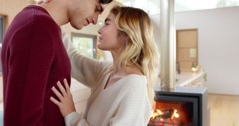 Loving Couple Embracing by Modern Fireplace