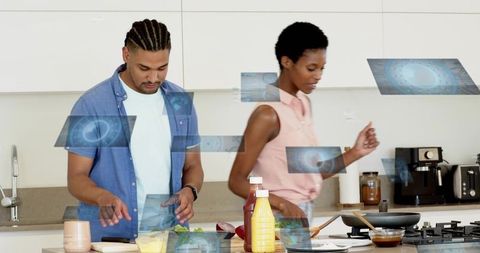 Young couple cooking together in modern kitchen with futuristic holographic interface