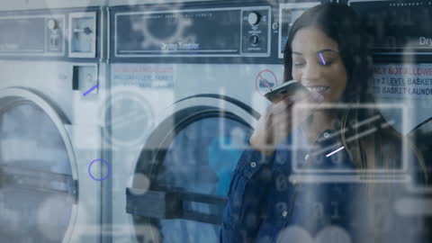 Woman Using Smartphone at Laundromat with Digital Interface