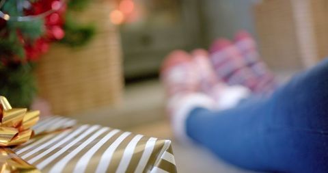 Christmas gift and cozy winter socks by fireplace