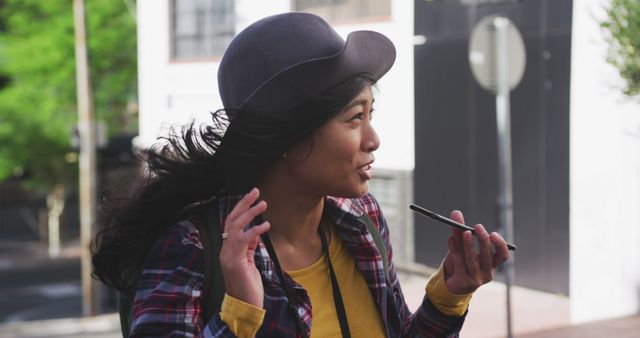 Young Woman in Hat Using Smartphone for Voice Messaging Outdoors - Download Free Stock Images Pikwizard.com