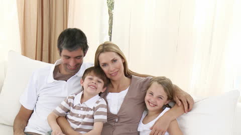 Happy Family Smiling Together on Cozy Couch