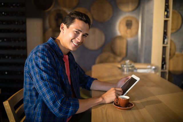 Portrait of smiling man using digital tablet in restaurant