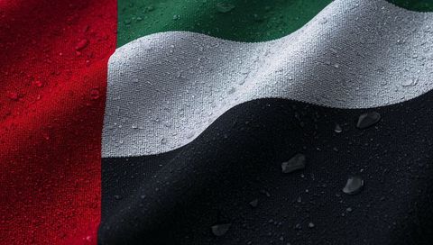 Uae flag fabric glistening with water droplets, macro woven textile detail