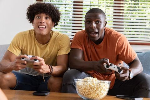 Enthusiastic Friends Gaming Together in Comfortable Living Room