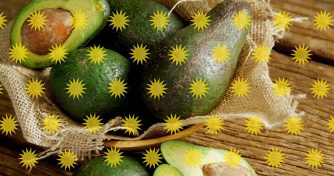 Ripe avocados resting in burlap basket on rustic wooden table, yellow starburst overlay
