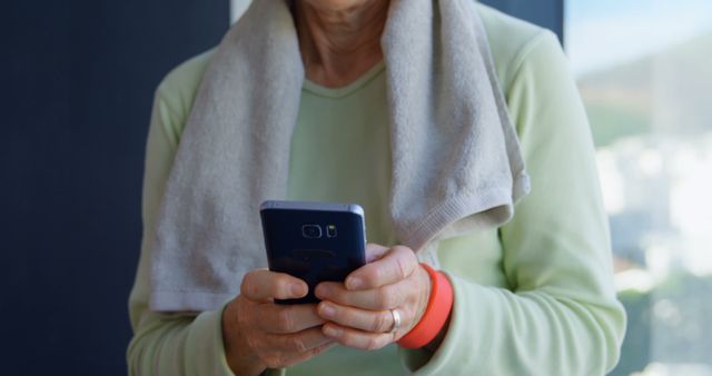 Senior woman using smartphone after exercise in gym - Download Free Stock Images Pikwizard.com