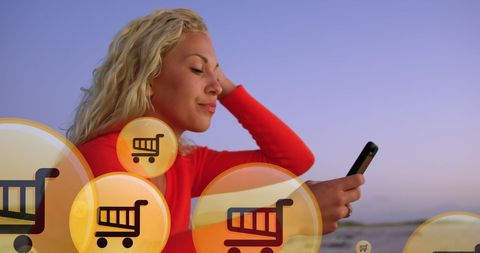 woman enjoying online shopping at beach with digital icons overlay - Download Free Stock Images Pikwizard.com