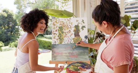 Mother and Daughter Painting Together Indoors