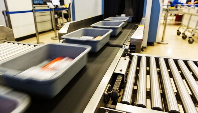 High-speed Security Conveyor Carrying Gray Bins Toward X-ray Scanner for Luggage Screening