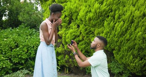 Happy couple engaged in garden surprise proposal