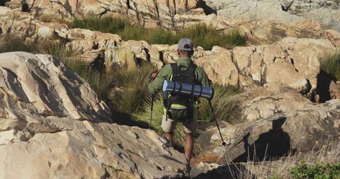 Hiker Exploring Rocky Hills with Trekking Gear