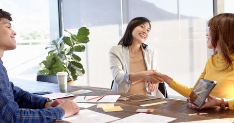 Diverse Business Team Engaging in Productive Meeting with Handshake