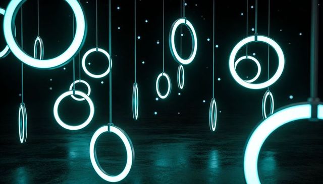 Glowing cyan neon rings hanging and casting reflections on glossy dark floor