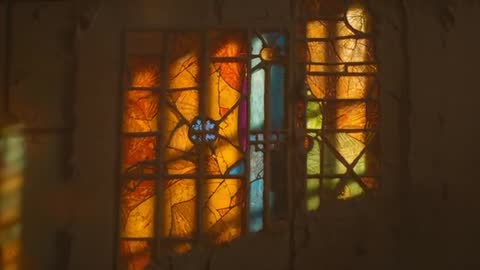 Light Play Through Stained Glass Creating Shifting Hues in Chapel