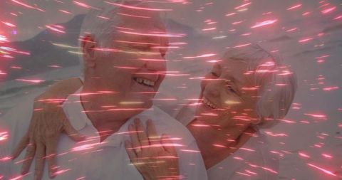 Happy senior couple in dreamlike pink light streaks