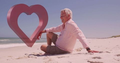 Senior Man Relaxing on Beach with Heart Graphic and Copy Space