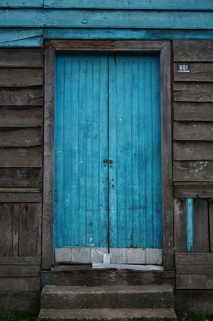 Aged blue wooden door in weathered rustic facade - Download Free Stock Photos Pikwizard.com