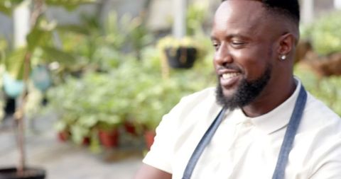 Man tending plants in nursery garden, horticulture lifestyle