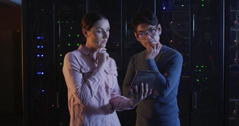 IT Engineers Analyzing Data on Tablet in Server Room