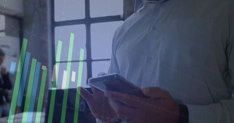 Man Analyzing Financial Data on Smartphone Indoors