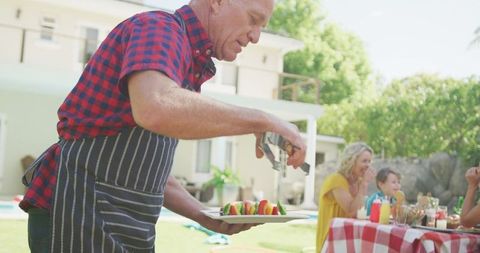 Family Enjoying Outdoor Barbecue Gathering in Sunny Garden