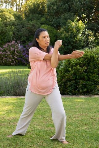 Pregnant Woman Practicing Calming Exercises Outdoors