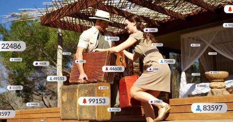 Couple moving vintage luggage on sunlit resort veranda surrounded by social icons