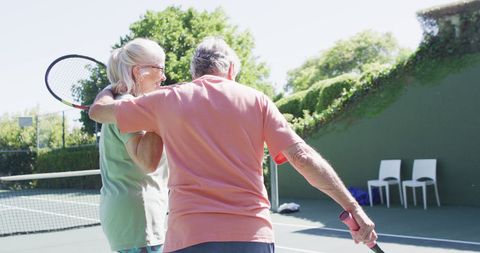 Smiling Senior Couple Enjoying Outdoor Tennis Game