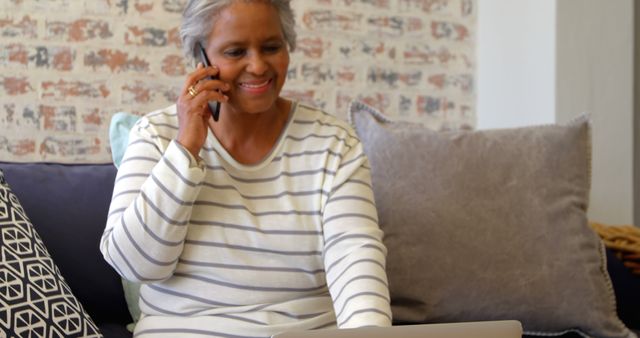 Happy Senior Woman Talking on Phone and Using Laptop at Home - Download Free Stock Images Pikwizard.com