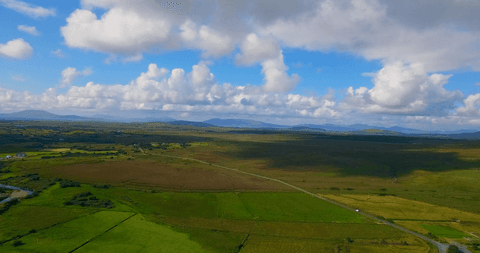 transparent view of expansive green fields and cloudy blue horizon - Download Free Stock Videos Pikwizard.com