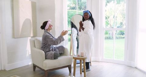Diverse women enjoying skincare in bright modern living room