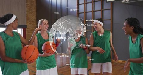 Smiling female basketball team celebrating on court with holographic global data overlay