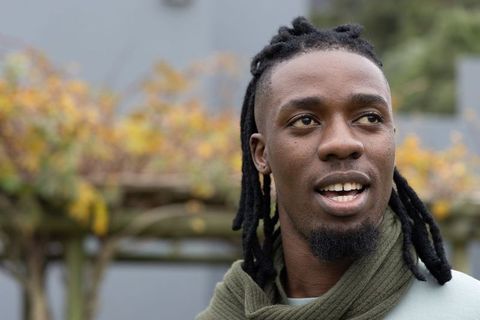 African american man speaking with dreadlocks and scarf outdoor autumn trellis portrait