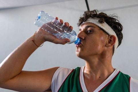 Teen Athlete Rehydrating during Workout in Gym Environment